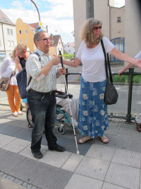 Marion Brülls und Manuel Rodriguez begutachten das Blindenleitsystem an der Haltestelle Augsburger Straße/Herz Jesu Kirche